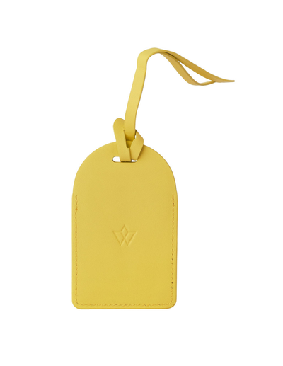 A yellow leather luggage tag with a matching leather loop strap, featuring an embossed Louis Vuitton monogram logo on the front, set against a plain white background.