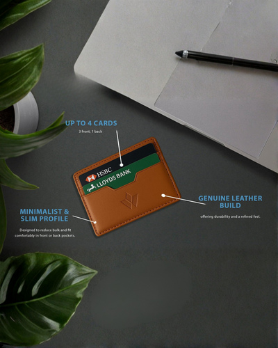 A tan leather slim cardholder wallet holding sample credit cards, shown on a dark tabletop with overlaid callout text and arrows explaining features. A pen, notebook, and green leaves are visible as styled props.