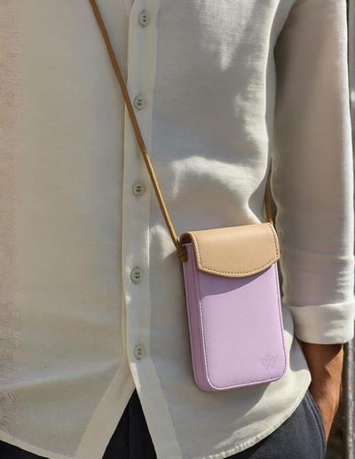 A lavender and beige crossbody phone pouch worn by a person wearing a white linen shirt.