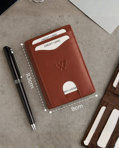 A brown leather card holder wallet shown on a gray textured surface, with a black pen beside it and dimension lines indicating 11.3 cm by 8 cm.