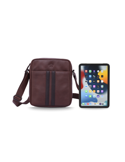A dark burgundy leather crossbody bag same size as an i-pad with a front zippered pocket and a matching adjustable shoulder strap, shown against a plain white background.