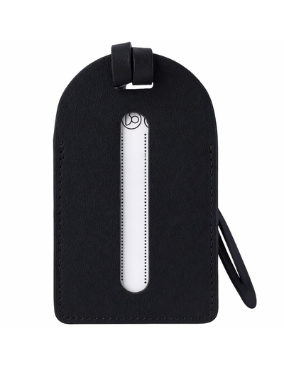 A black textured leather luggage tag with a vertical oval cutout showing a white insert, featuring a top loop and a side strap on a plain white background.