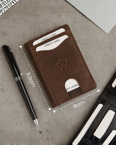 A brown leather card holder wallet with card slots and a coin pocket, shown on a gray textured surface with a black pen and partial props. White dashed lines and text indicate dimensions of 11.