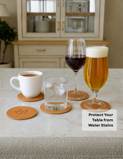 Round tan leather table coasters shown in a kitchen setting, with a white mug, glass of red wine, glass of beer, and a glass of water resting on them. A text overlay reads 'Protect Your Table from Water Stains'.
