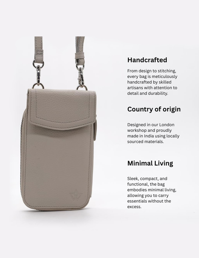 A light taupe leather crossbody phone bag shown on a clean white background with descriptive text on the right detailing its handcrafted quality, country of origin, and minimalist design.