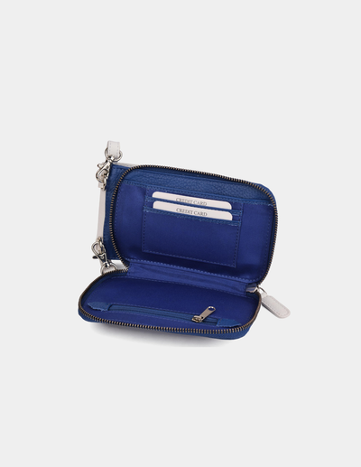 An open zip-around wallet in white blue, showing interior card slots and a wristlet strap, photographed on a plain light gray background.
