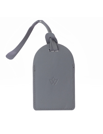 A gray leather luggage tag with a matching leather strap and a debossed monogram logo, shown on a plain white background.