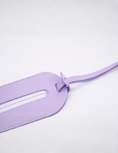 A light purple leather luggage tag with a matching strap, shown on a plain white background.